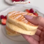 fluffy pancakes with strawberries and syrup